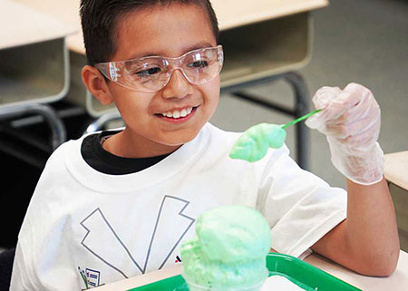 An elementary school student admires his Matter Monsters experiment